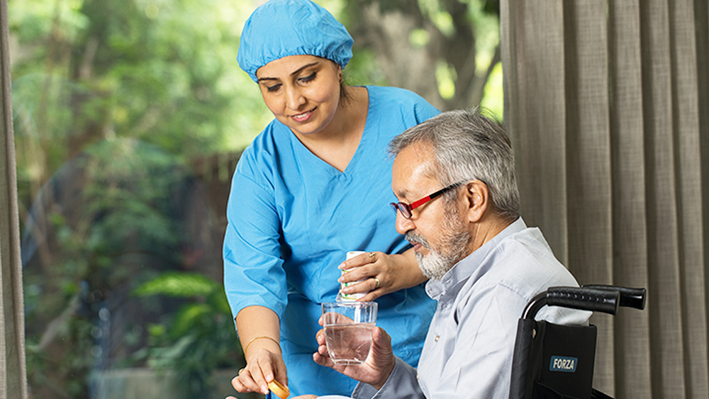 Indian nurse caring for elderly woman in Kolkata